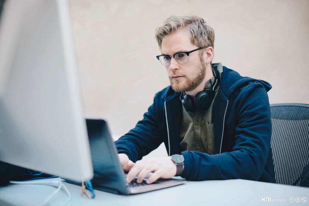 Mannlig dataprogrammerer skriver på laptop. Foto.