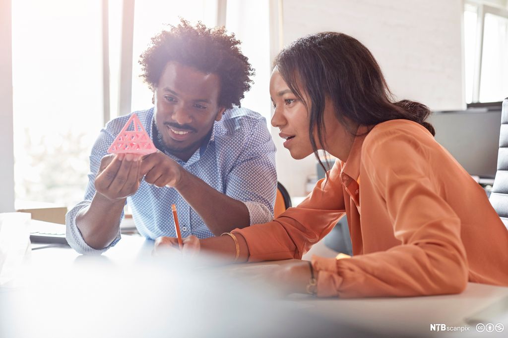 To personer vurderer en prototyp. Foto.