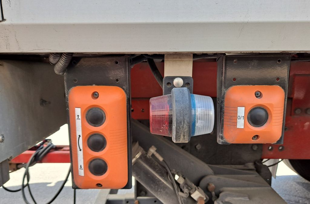 To oransje bryterpanel er montert ved siden av hverandre. Det til venstre har tre knapper, det til høyre har én. Foto