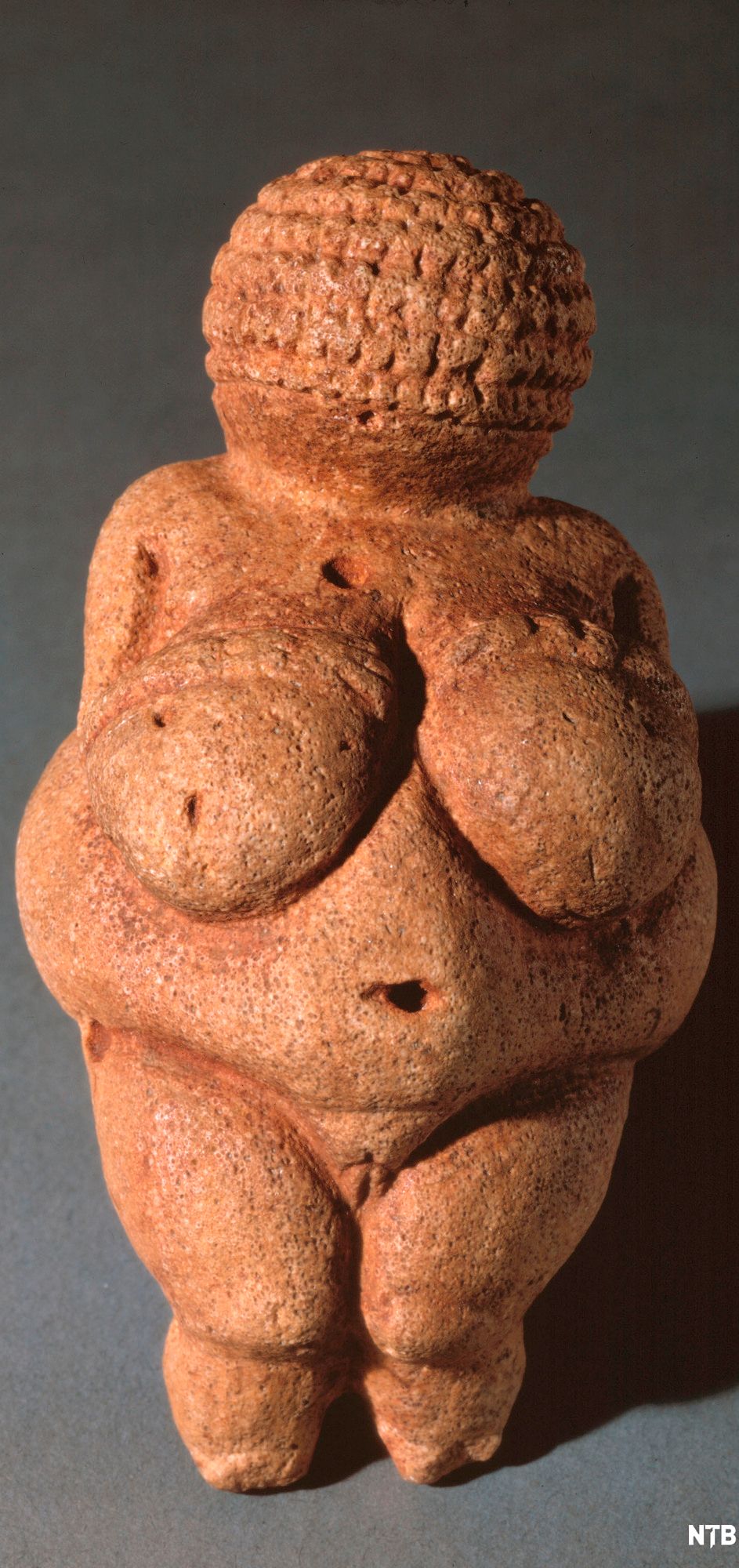 Skulptur av frodig kvinneskikkelse i sandstein. Foto.