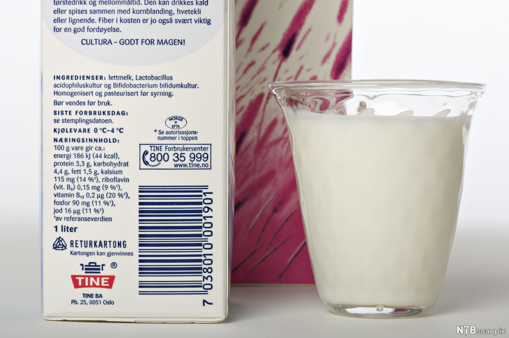 Nærbilde av et glass med melk ved siden av to melkekartonger. Foto.