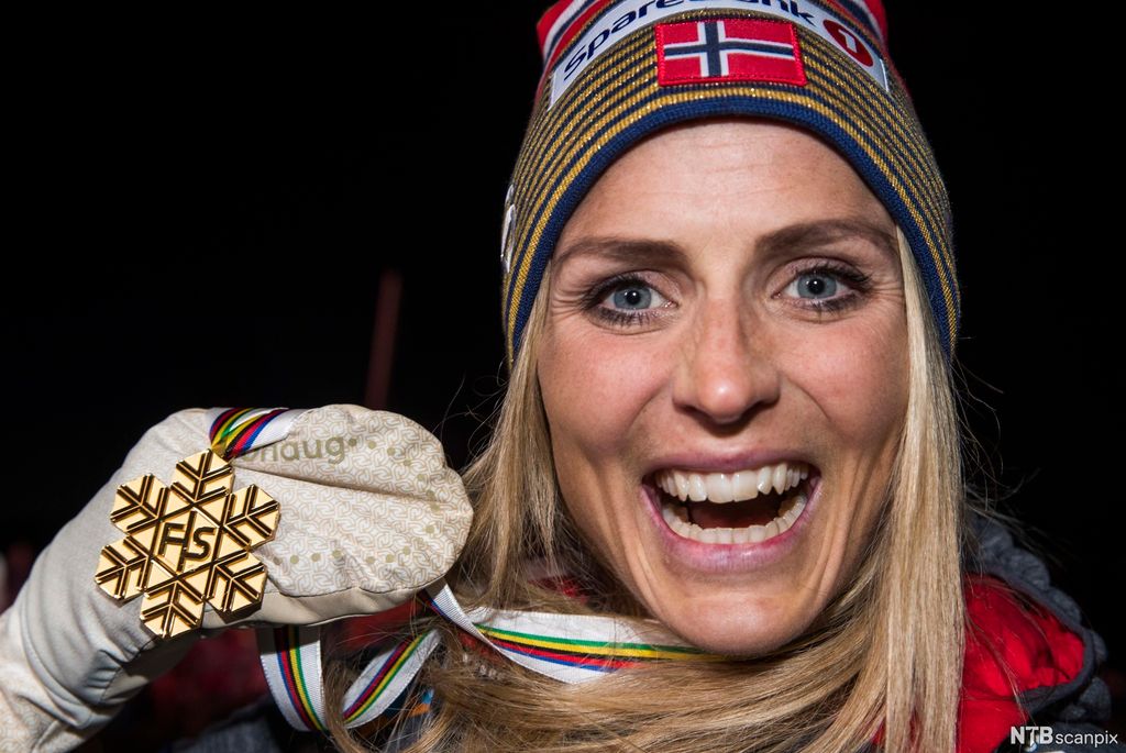 En smilende jente med gullmedalje. Foto.