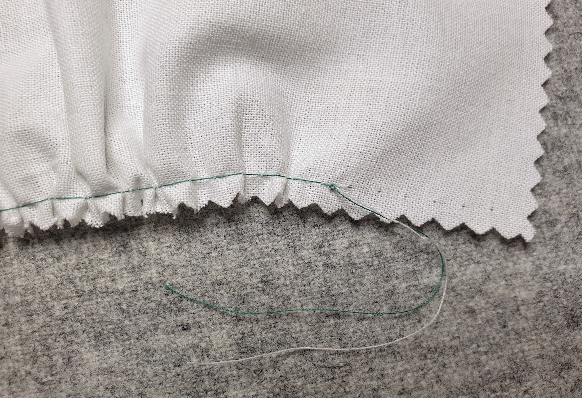 Fotografi som viser at det er knyttet knute på endetråden på en prøvelapp med rynker.