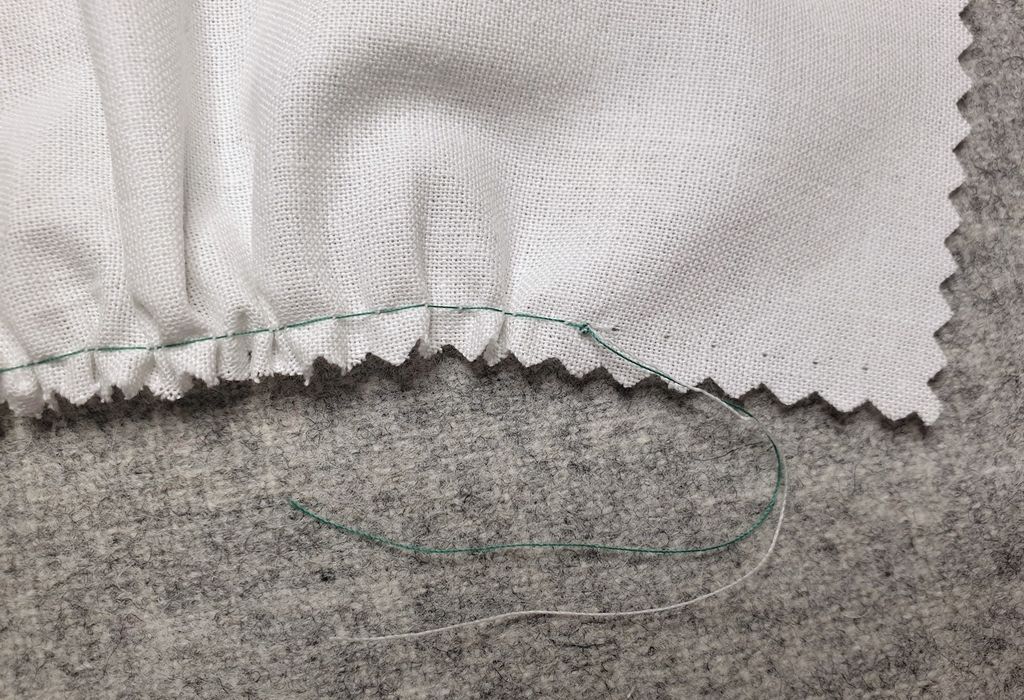 Fotografi av at det er knyttet knute på endetråden på en prøvelapp med rynker.