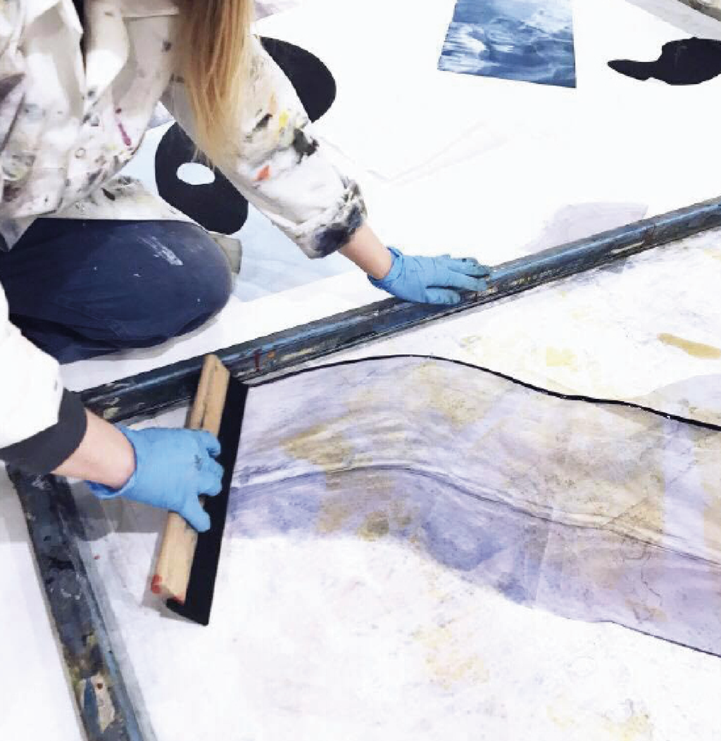 Designer arbeider med et silketrykk. Foto.