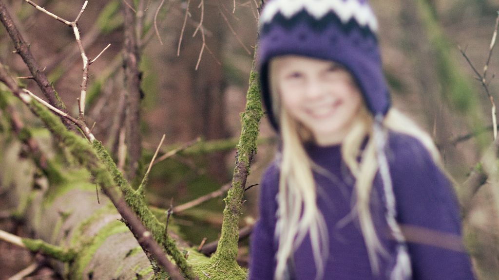 Jente fotografert i skogen. Fokusfeil har oppstått i bildet. Modellen er uskarp. Foto.