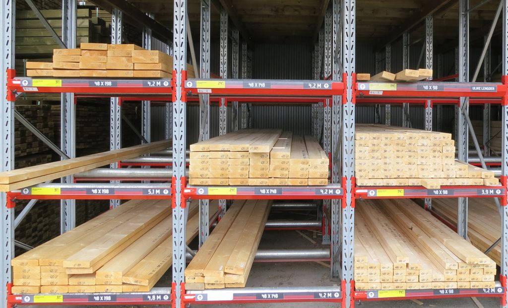 Trelast lagret i hyller. Foto.
