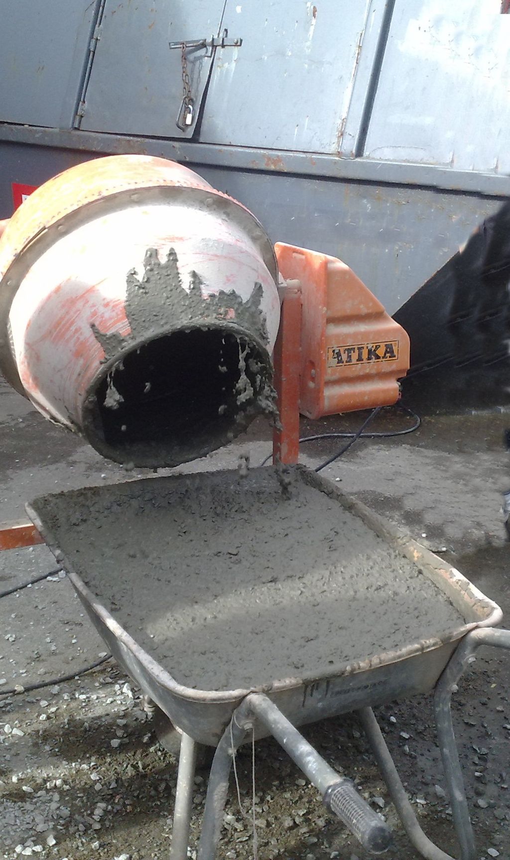 Mørtelblander og trillebår med betong. Foto.