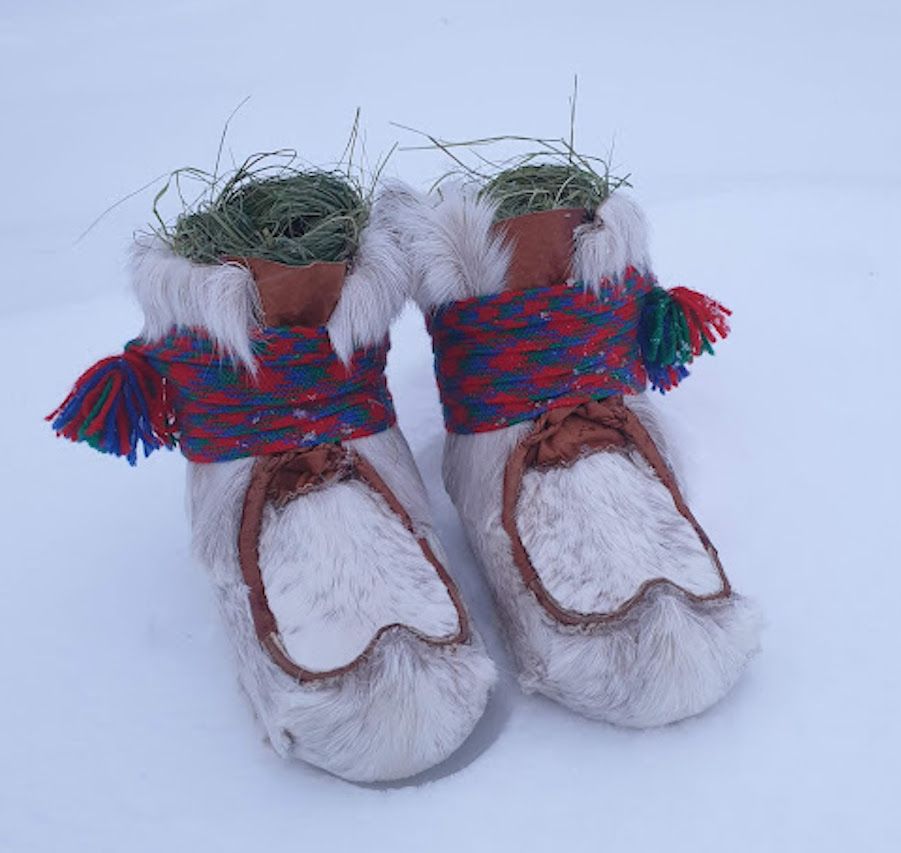 Eit par skallar med band står på snøen. Foto.