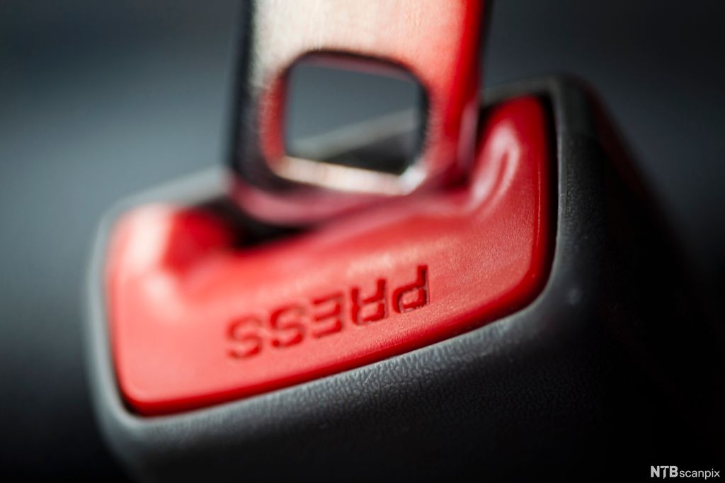 Lås til setebelte der der står press. Foto. 