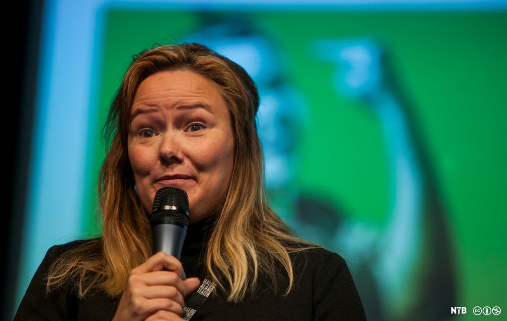 Kvinne opptrer med mikrofon. Foto.
