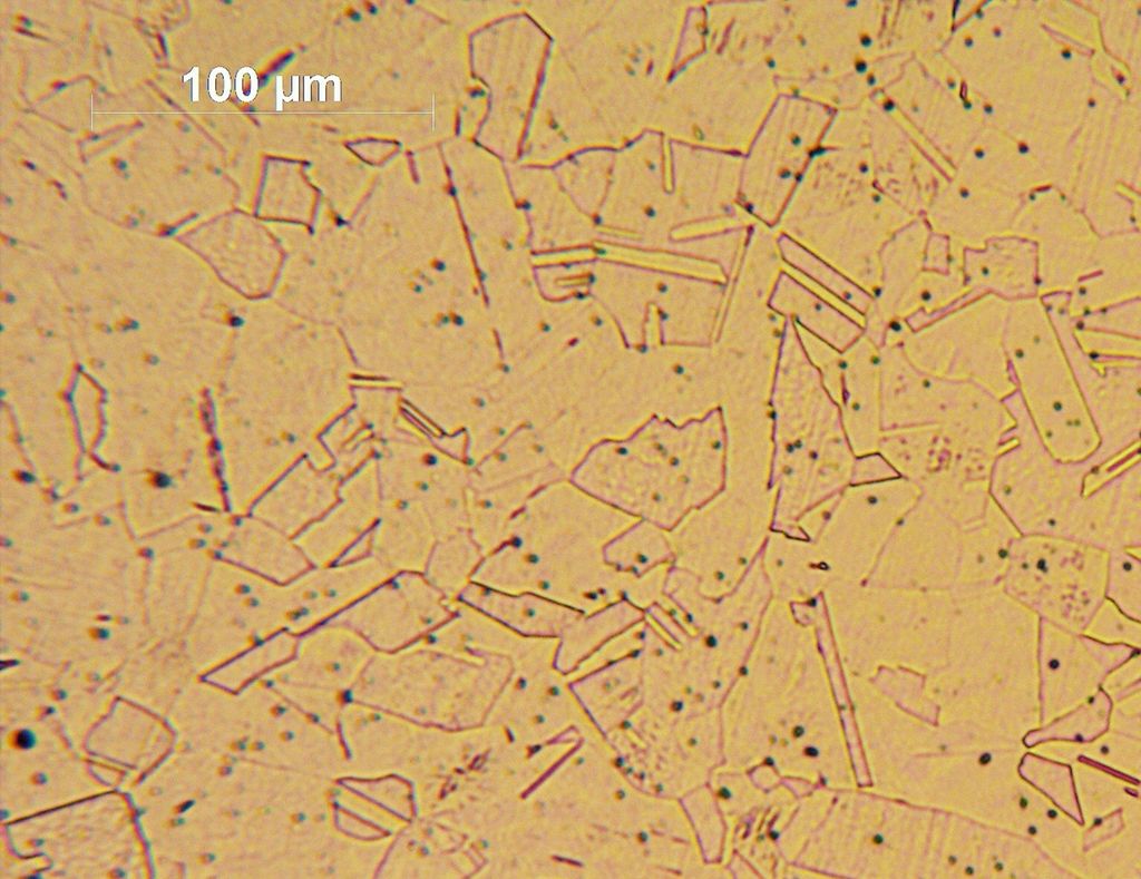 Kornstruktur i stål. Molekylene har ulik størrelse og er spredd uregelmessig i overflata. Foto.
