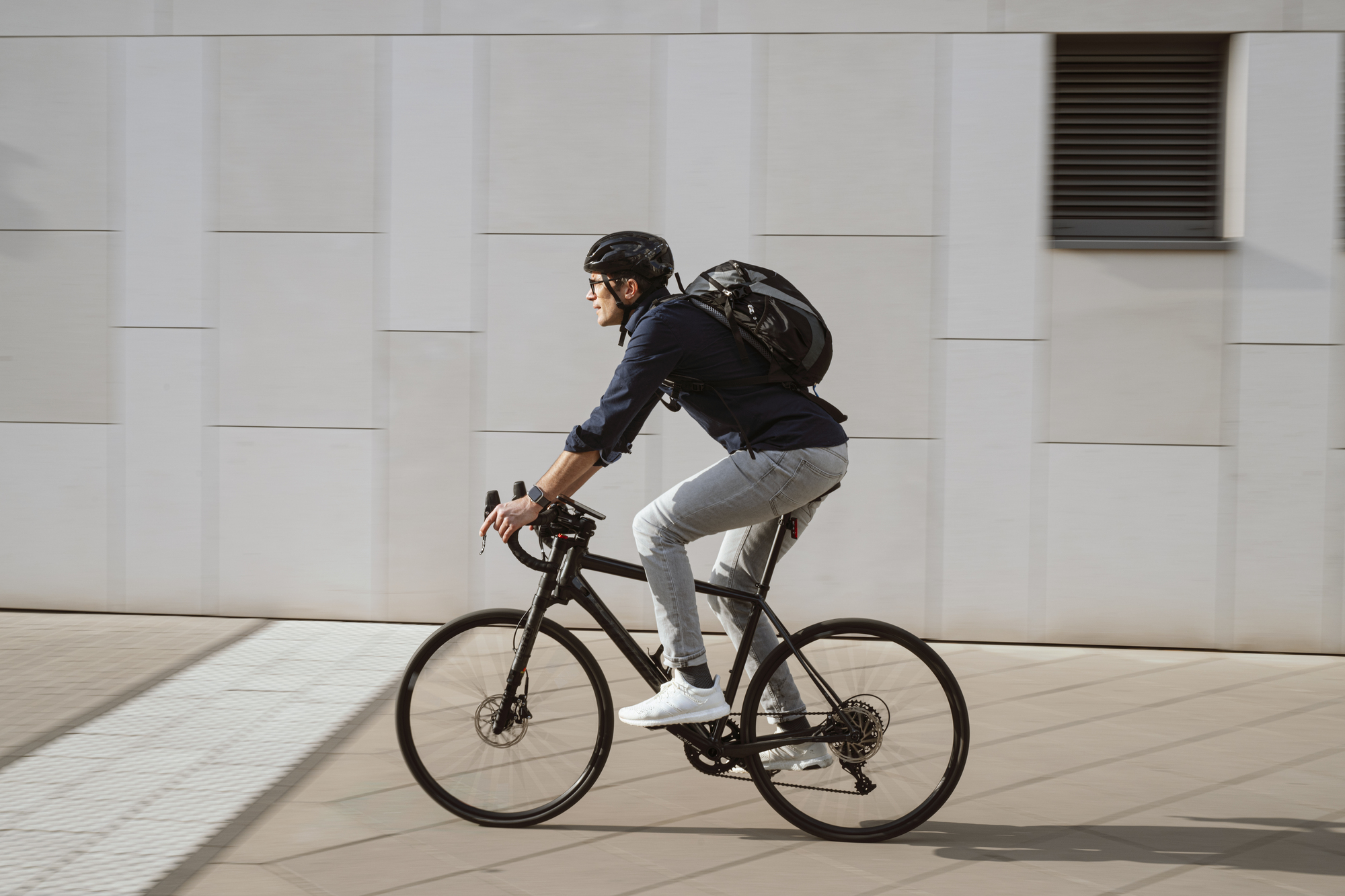 En mann sykler i byen. Foto.