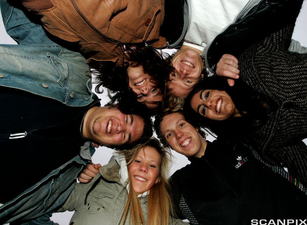 Seks ungdommer står i ring og ser ned i kamera. Foto.