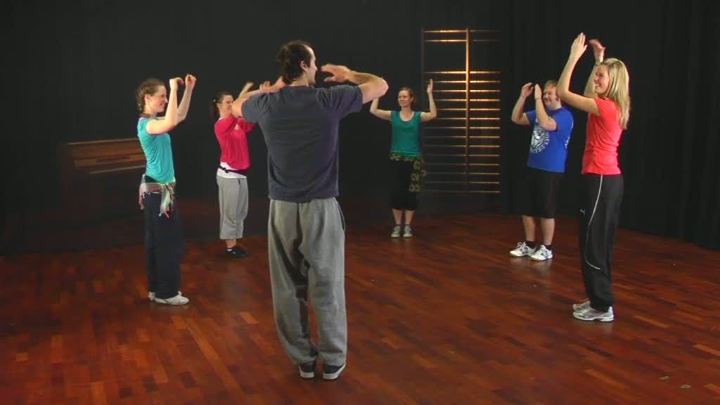 Personer står i en ring og klapper. Foto.