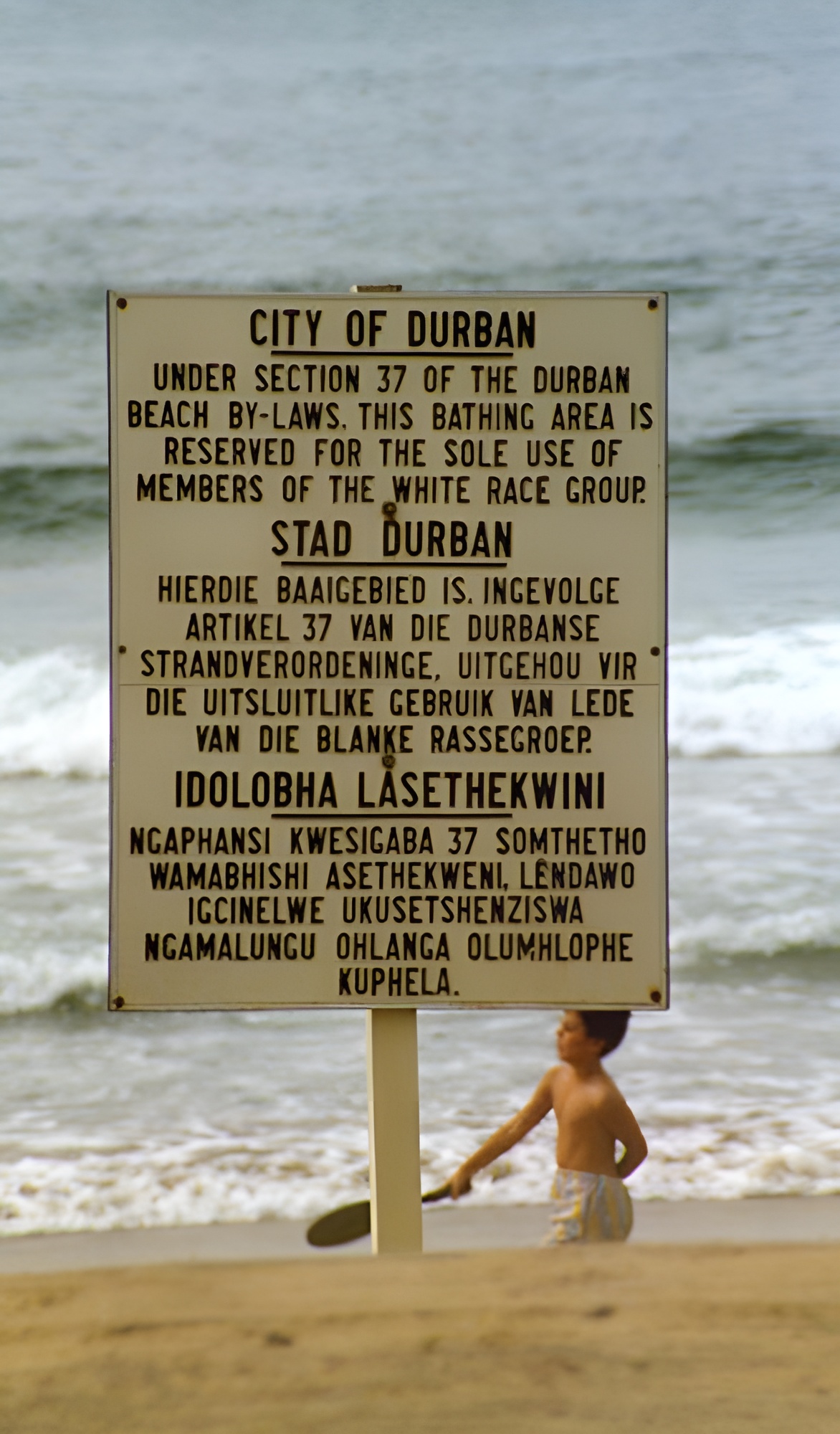 Sign in Durban that states the beach is for whites only under section 37 of the Durban beach by-laws. The languages are English, Afrikaans and Zulu, the language of the black population group in the Durban area. Photo.