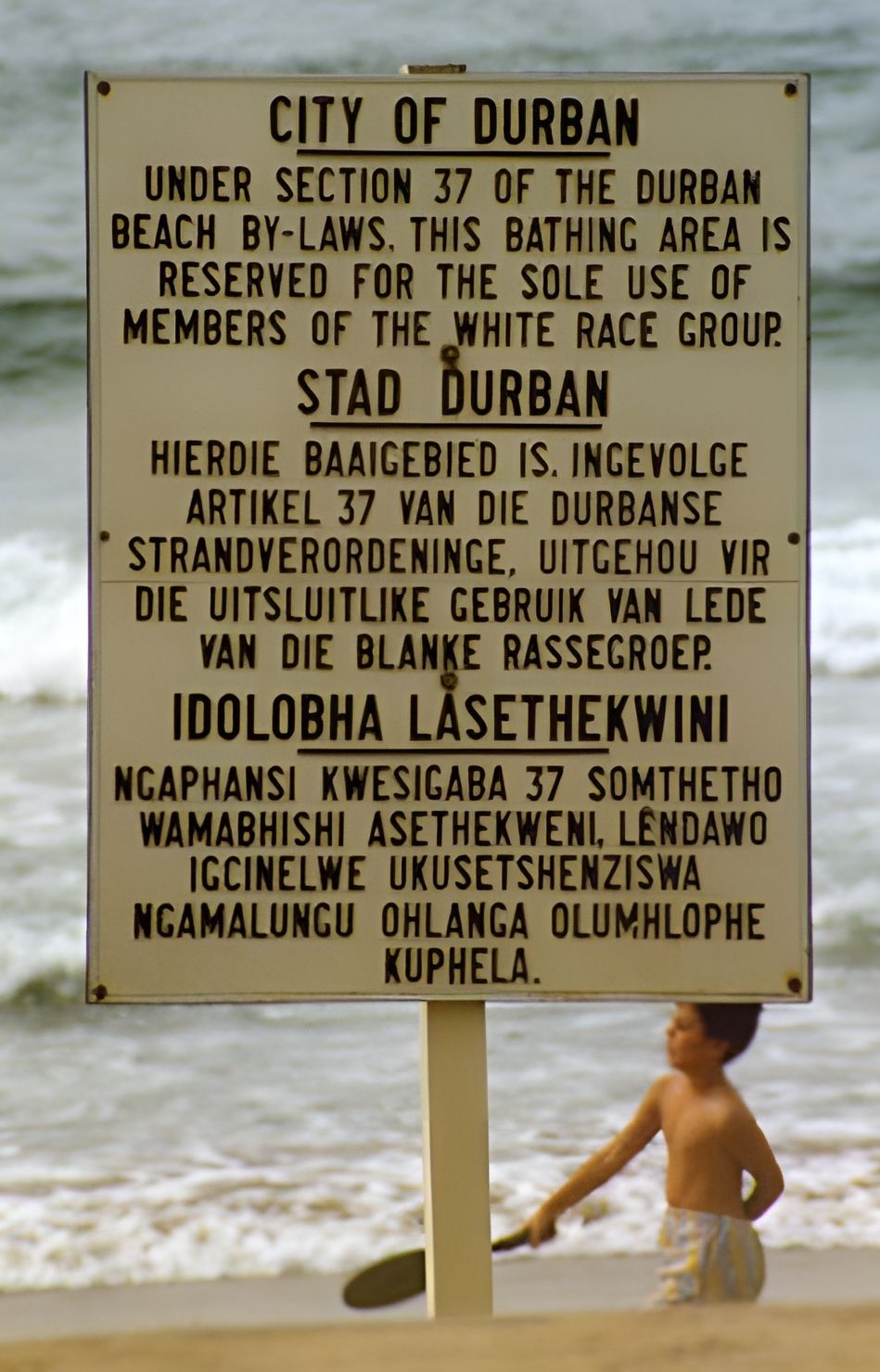 Sign in Durban that states the beach is for whites only under section 37 of the Durban beach by-laws. The languages are English, Afrikaans and Zulu, the language of the black population group in the Durban area. Photo.