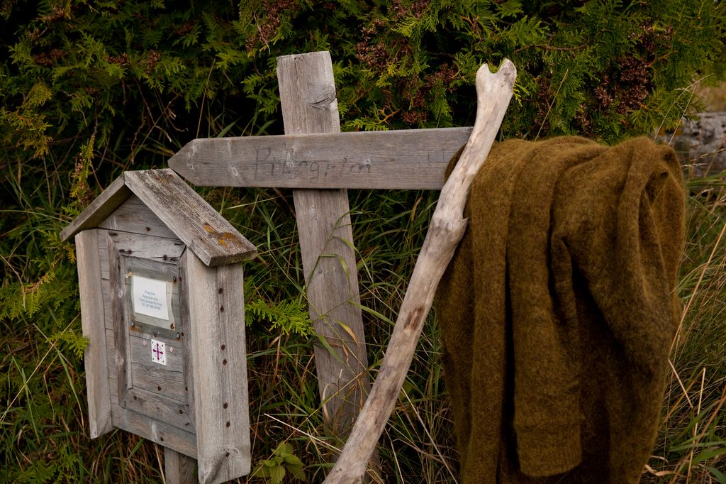 Et pilegrimsskilt og en vandrestav. Foto.