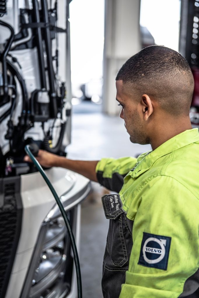 En mekaniker utfører service på et kjøretøy. Foto.