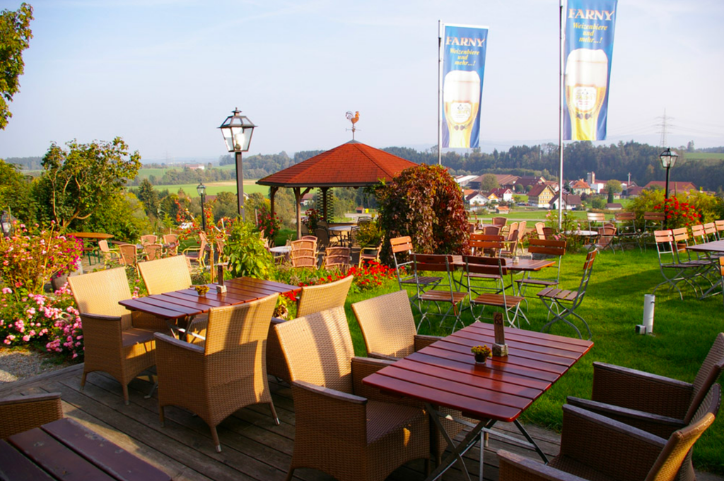 Tysk Restaurant, Biergarten. Tomme bord i en restaurant i flott landskap. Uteservering. Foto.