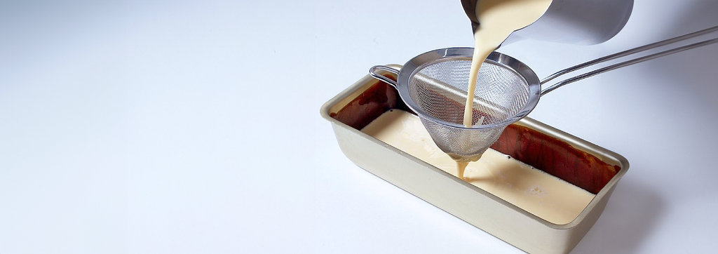 Fylling av brødform med karamellsmete. Foto.