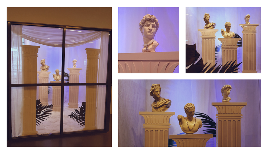 Vindusutstilling med greske søyler og torsoer. Foto.