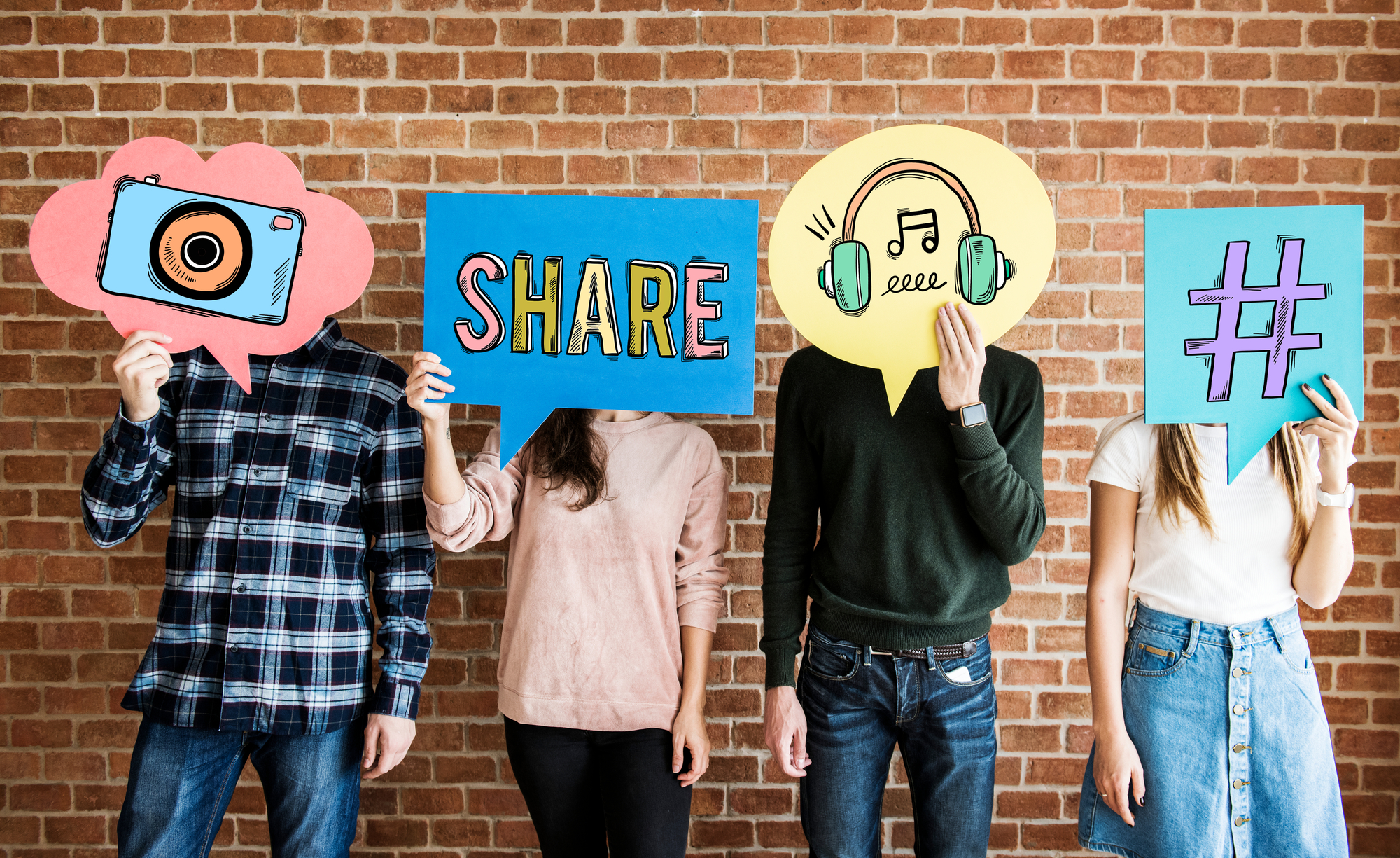 Two boys and a girl hold posters with social media symbols in front of their faces. Photo.