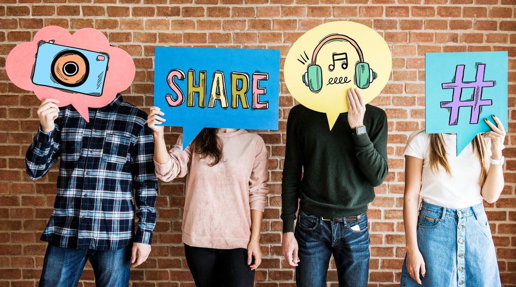 Two boys and a girl hold posters with social media symbols in front of their faces. Photo.