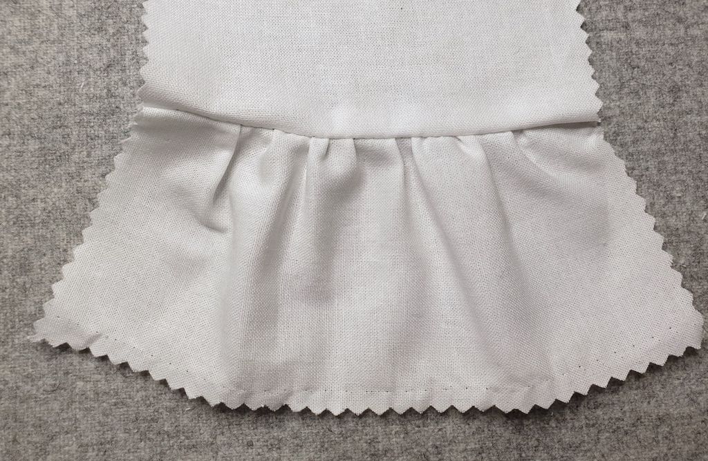 Fotografi av prøvelapp med ferdig sydd rynkesøm.