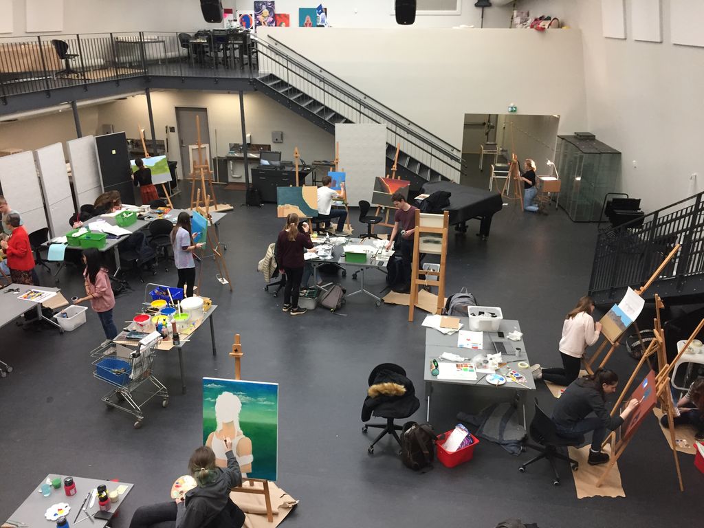 En tegnesal med elever som maler bilder. Foto.