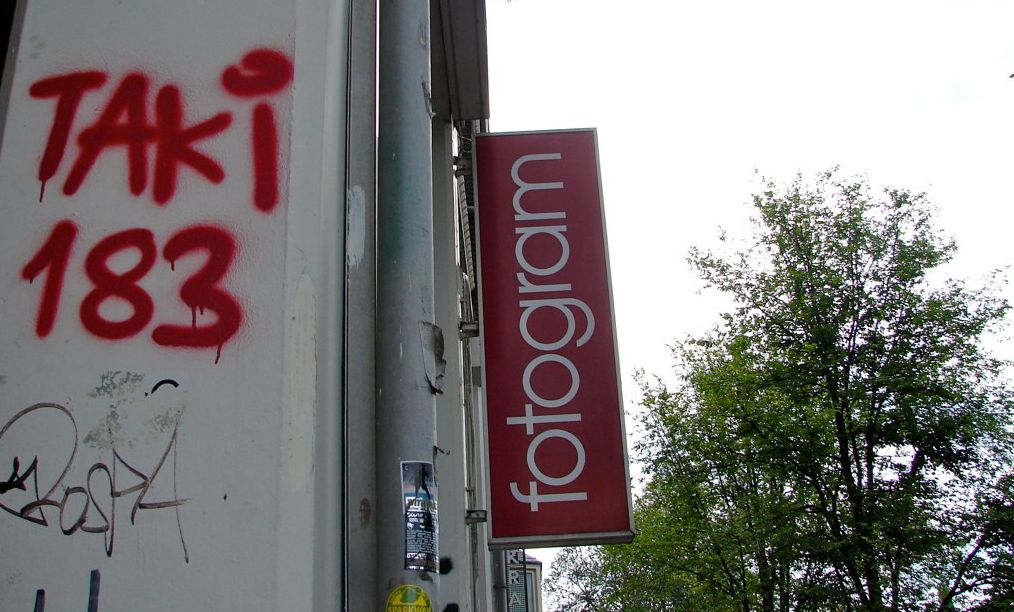 En murvegg med "TAKI 183" i rød graffitiskrift. Foto.