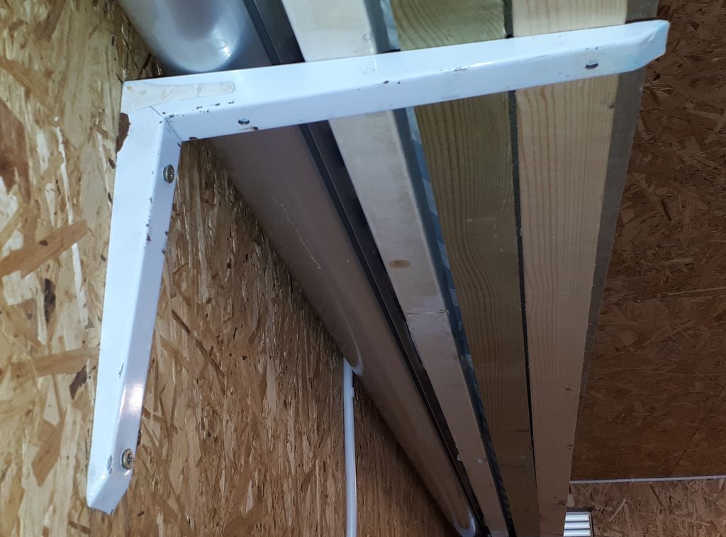 En konsoll eller en hylleknekt holder materialer på en vegg. Foto.