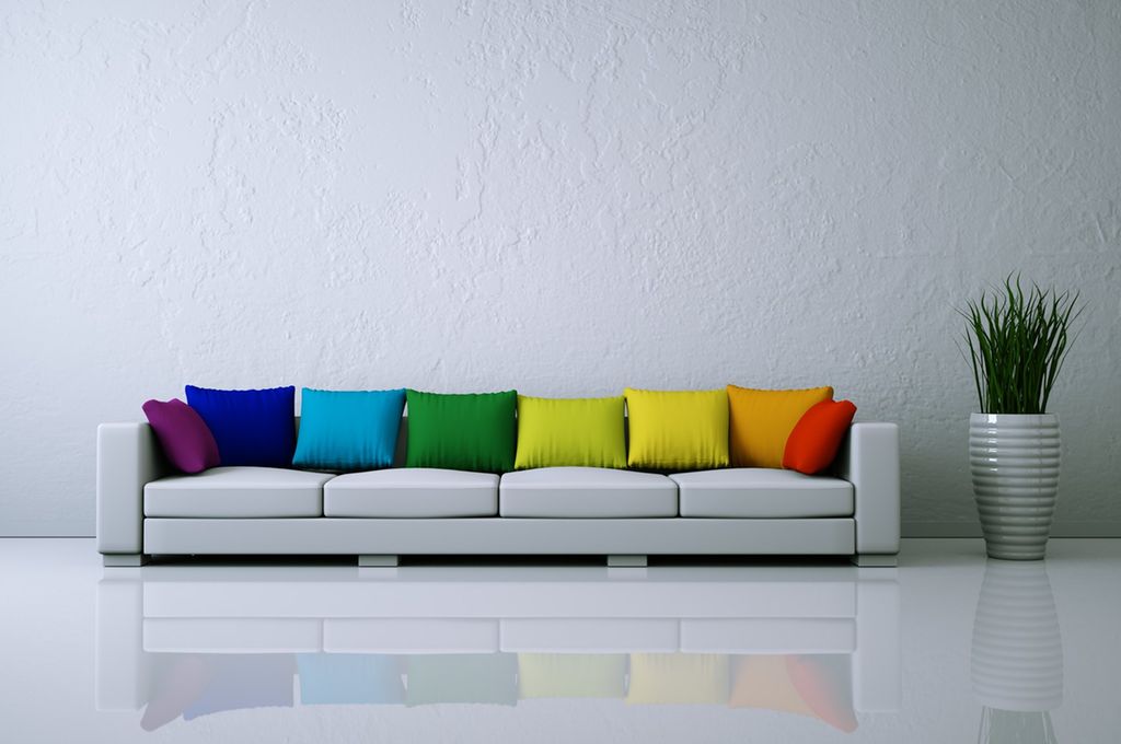 Hvit sofa med fargerike puter. Foto.