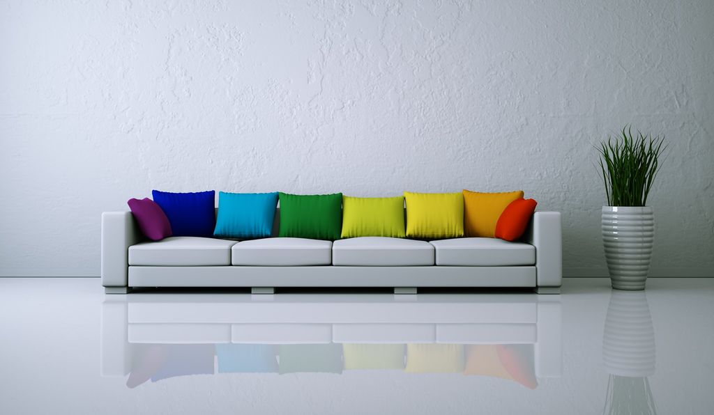 Kvit sofa med fargerike puter. Foto.