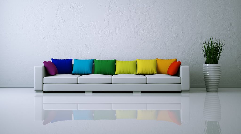 Hvit sofa med fargerike puter. Foto.