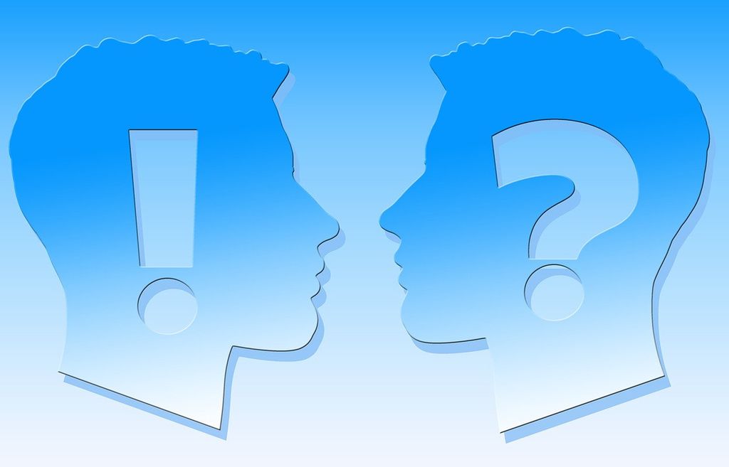 Profile of two heads, one has a large exclamation point, the other a question mark. Illustration.