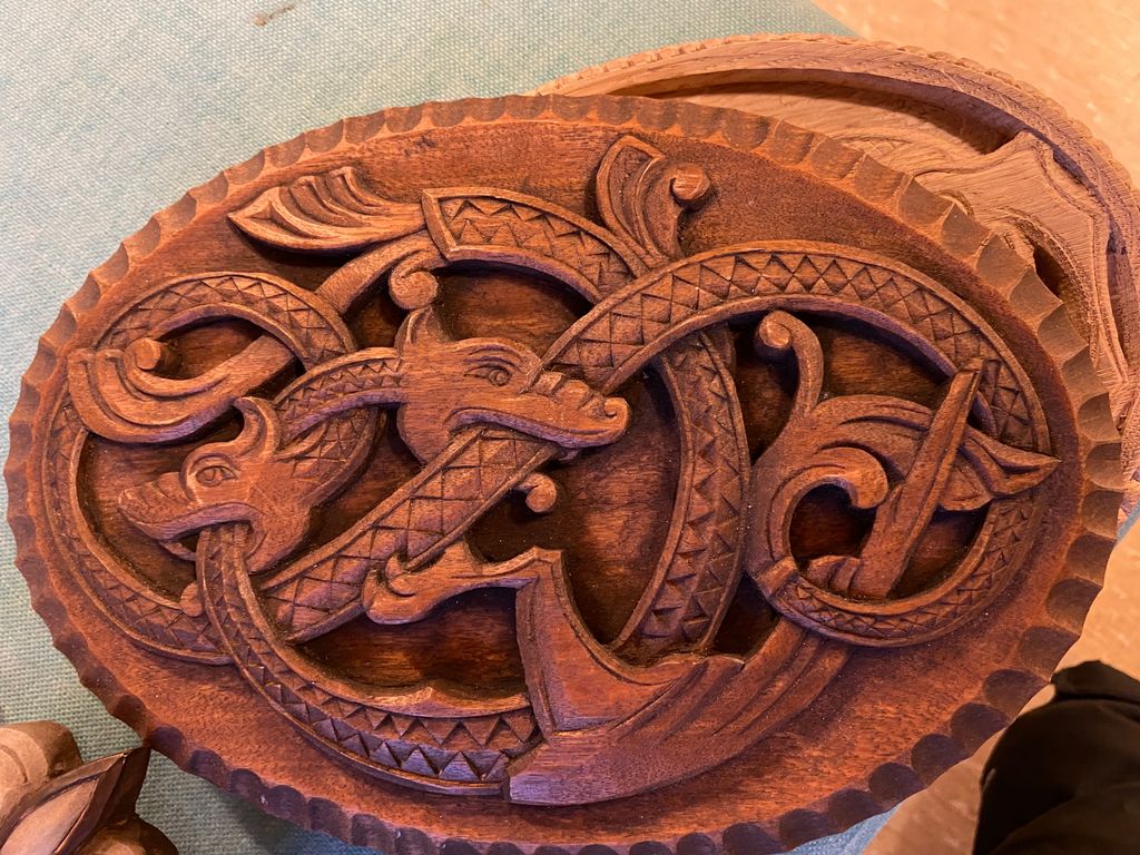 Ovalt lokk med treskjæringsdekor i dragestil. Foto.