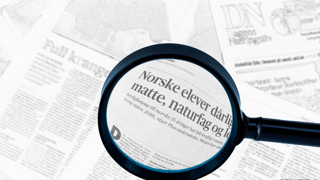 Forstørrelsesglass over avisside. Foto.