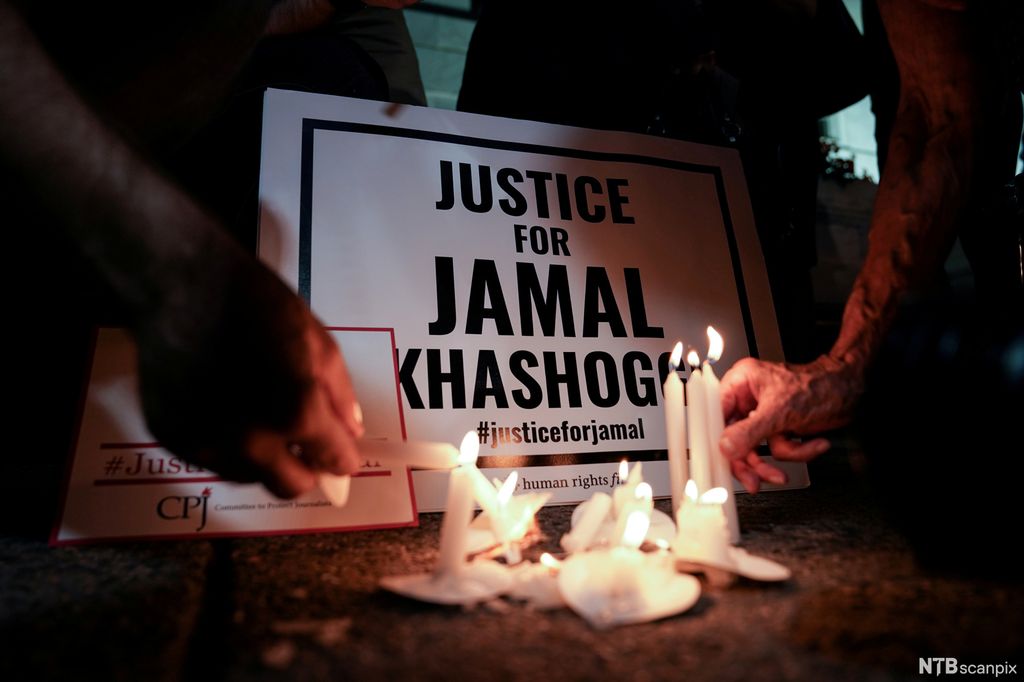 Candles are lit in front of a poster saying Justice for Jamal Khashoggi. Photo.