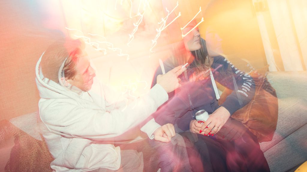 Gutt tilbyr ei jente en joint på fest. Jenta holder en ølboks i hånda og ser bort. Foto.
