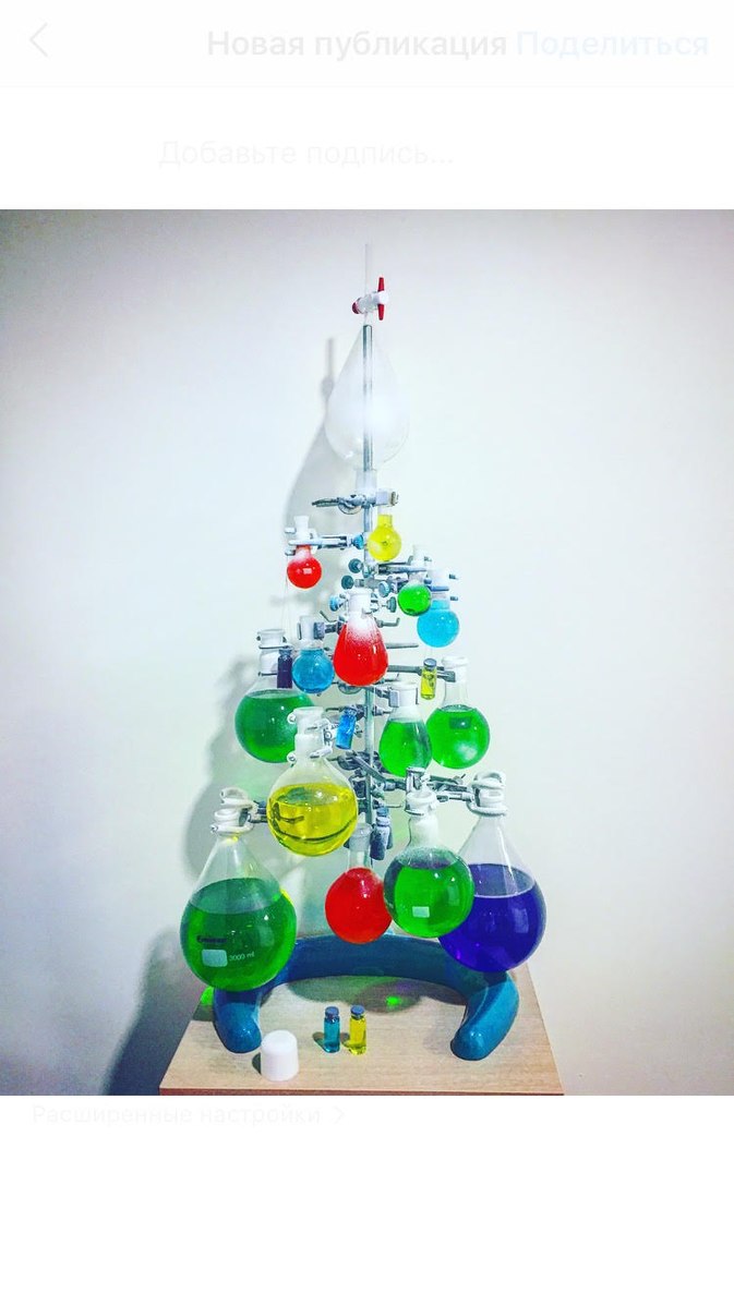 Juletre laget av stativ med kolber med fargerike væsker. Foto.