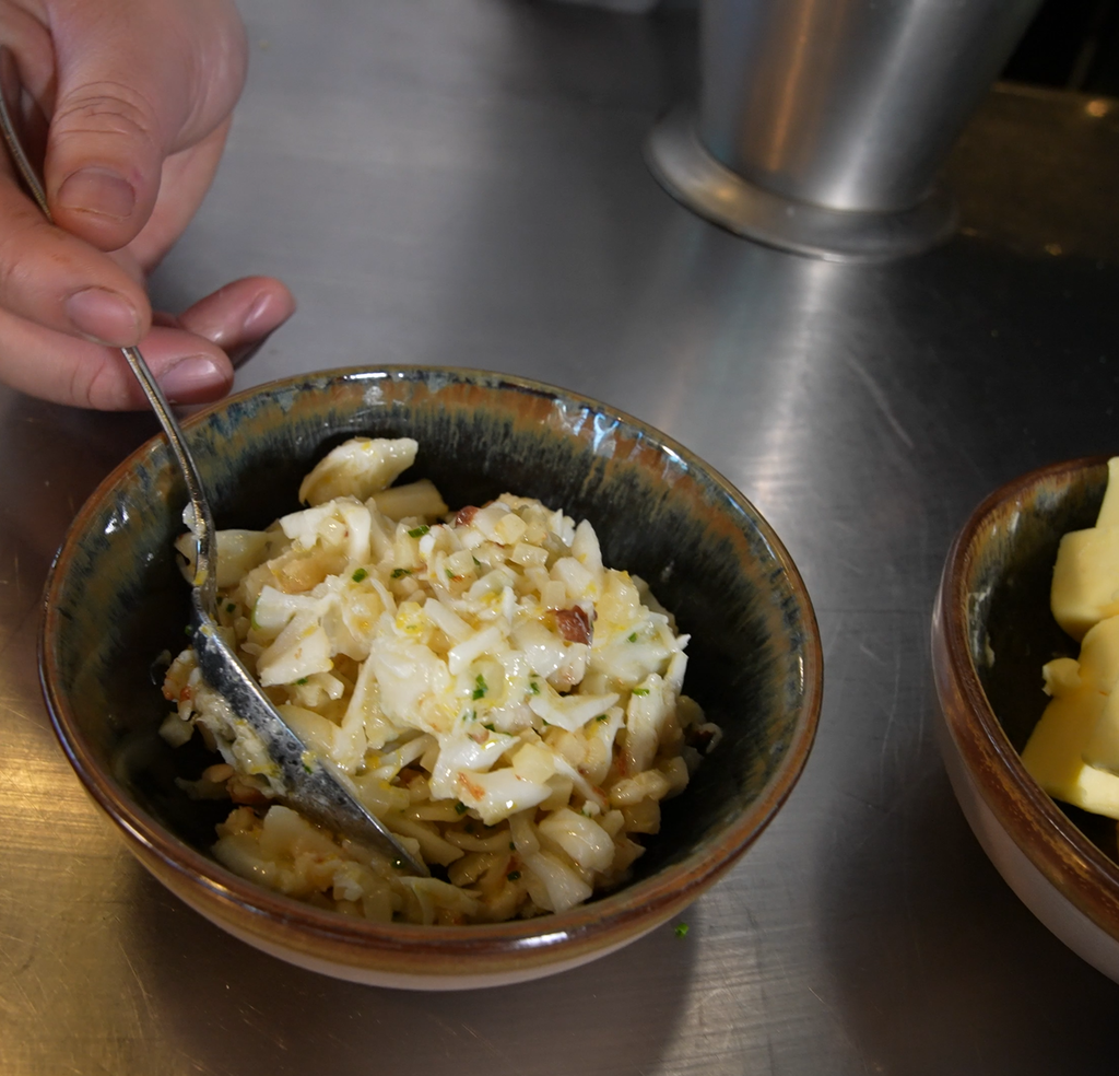 En skål med et fyll laget av torskekjaker, sitronzest og gressløk. Foto.