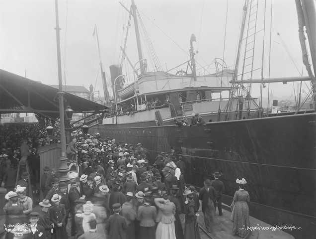 En stor folkemengde foran et skip. Svart-hvitt-foto. 