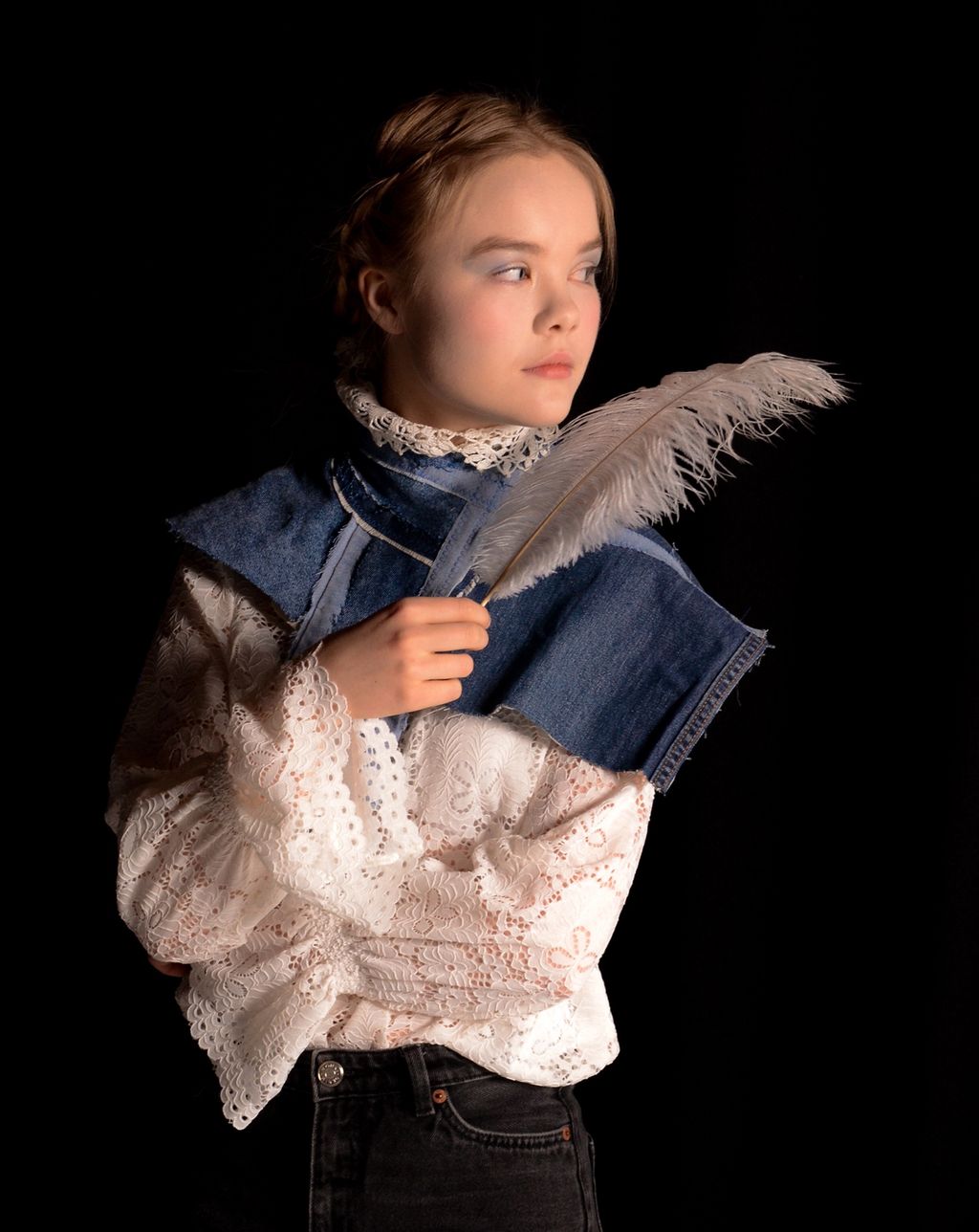 Portrett av jente med fjær og skulpturell krage. Foto.